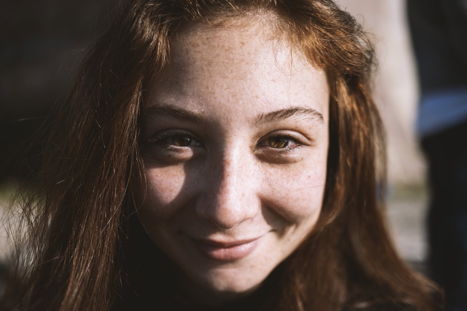 Primo piano sorridente di una donna illuminata dal sole