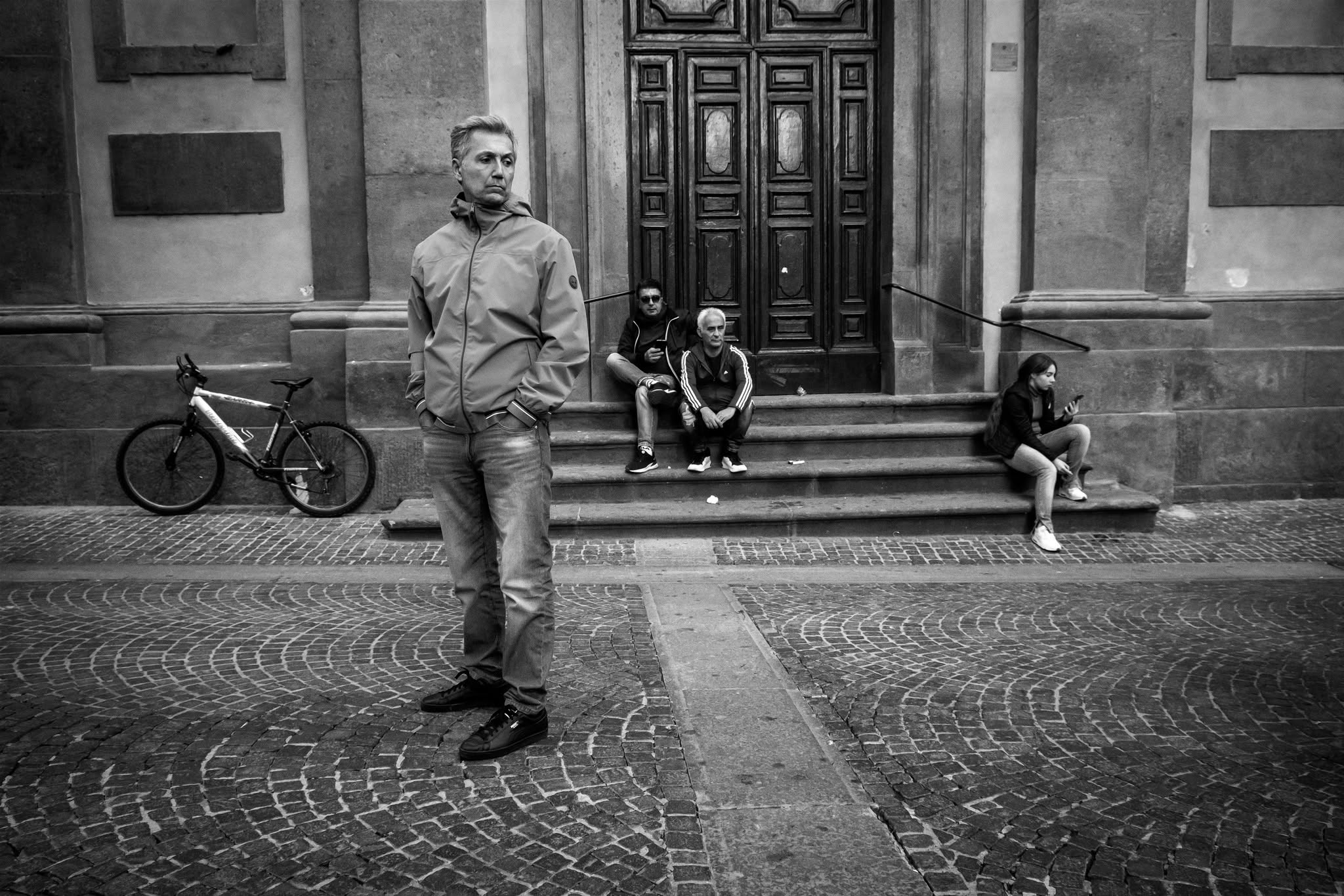 Persone in strada davanti al portale di un edificio storico